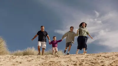 a family running on the sand on a beach at E42 Vista Marina, Riviere Towans in Hayle