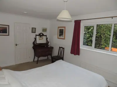 a bedroom with a bed and a desk and a window at Oxencombe in Davidstow