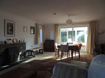 a living room with a table and a fireplace at Oxencombe in Davidstow