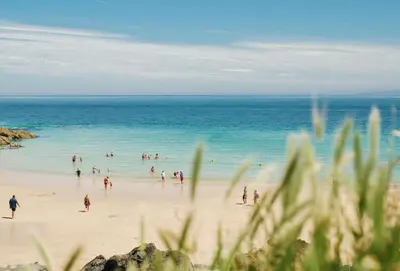 a group of people playing in the water on a beach at Little Puffin Way in Hayle