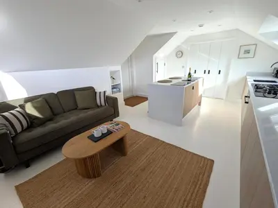 a living room with a couch and a table at Cober Riverside Retreat - Luxury Barn Apartment in The Heart of Cornwall in Wendron