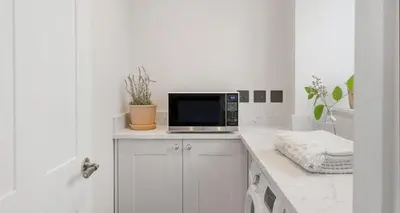 a microwave sitting on top of a counter in a kitchen at Luxury seaside home - 5 mins walk to beach - hot tub in Downderry
