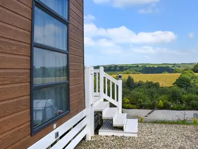 a wooden house with a white staircase next to a window at Valley View - Uk50320 in Liskeard
