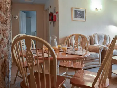a living room with a wooden table and chairs at Henhouse - Uk49016 in Liskeard