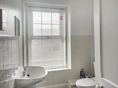a bathroom with a sink and a toilet and a window at The Farmhouse - Uk49068 in Liskeard