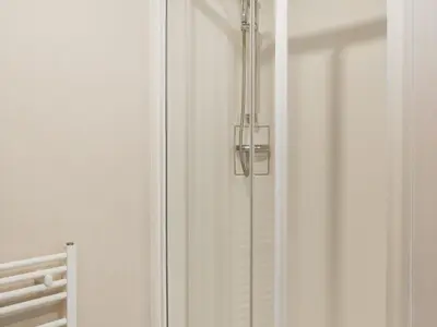 a shower with a glass door with a light on it at Edmonton Lodge - Uk50308 in Doublebois
