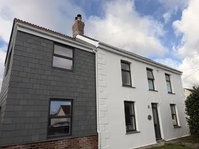 a white house with a chimney on top of it at 4 Bed in Bugle oc-f34175 in Penwithick