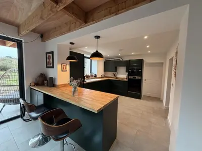 a kitchen with black cabinets and a wooden counter top at 4 Bed in Bugle oc-f34175 in Penwithick
