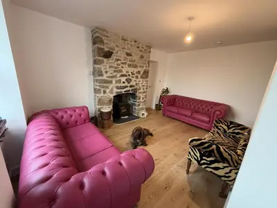 a living room with a purple couch and a fireplace at 4 Bed in Bugle oc-f34175 in Penwithick