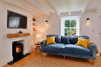 a blue couch in a living room with a fireplace at Finest Retreats - Mill Stone Cottage in Nancledra