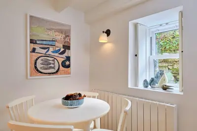 a white table and chairs in a room with a window at Finest Retreats - Mill Stone Cottage in Nancledra