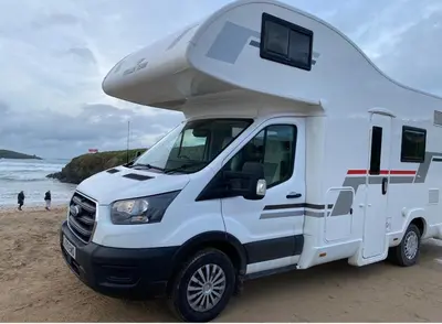 a white camper truck parked on the beach at Raffy The Motorhome in St Merryn