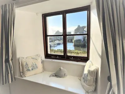 a window in a room with a window seat with a view at Warren Cottage in the pretty village of Polperro in Polperro