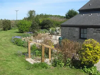 a garden with a wooden fence in front of a house at Lilliput Mabe far views of the countryside in Budock Water