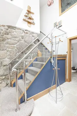 a staircase in a house with a stone wall at Dippers woodland setting at the Luxulyan Valley in Luxulyan