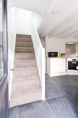 a staircase in a kitchen with white walls and tile floors at Tramanda a rural retreat to explore Bodmin Moor in Blisland