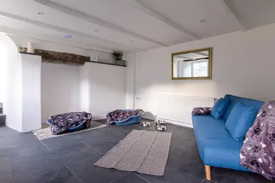 a living room with a blue couch and a mirror at Tramanda a rural retreat to explore Bodmin Moor in Blisland