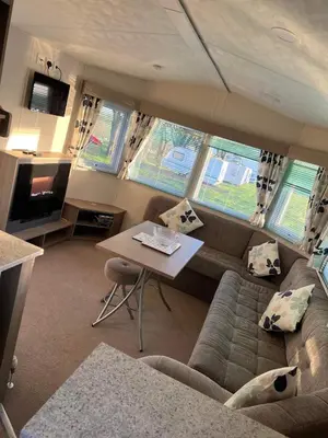 a living room with a couch and a table at Static Caravan 9 in Lansallos