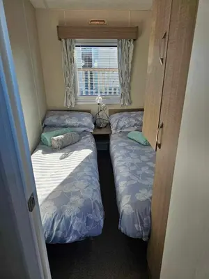a small room with two beds and a window at Static Caravan 9 in Lansallos