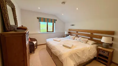 a bedroom with a large bed and a mirror at The Vineyard in Fowey