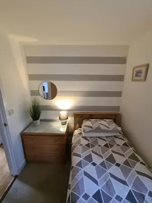 a bedroom with a bed and a lamp on a dresser at Inny Glade in Davidstow