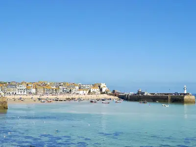 a beach with a bunch of boats in the water at Elm - 31304 in Porthtowan