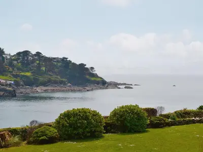 a view of a body of water with bushes at The Pool House in Tywardreath