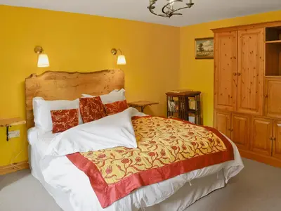 a bedroom with a large bed with yellow walls at Tucked Away in Linkinhorne