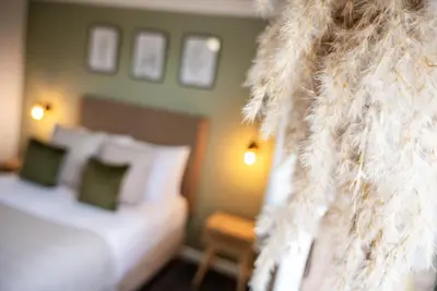 a room with a bed and a couch with pillows at The Inn For All Seasons in Redruth