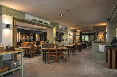 a restaurant with tables and chairs in a room at The Inn For All Seasons in Redruth