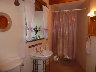 a white bathroom with a sink and a shower at The Old Wagon House in Saint Clether