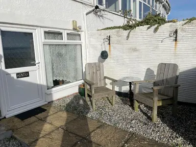 two chairs and a table in front of a building at Sawyers Bed and Breakfast in Looe