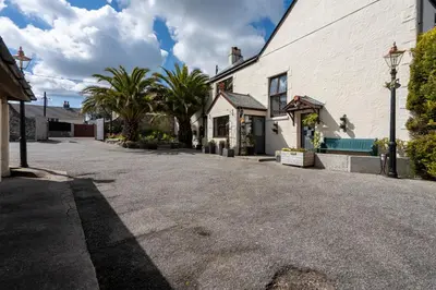 an empty street in front of a white building at The Cedars in Redruth