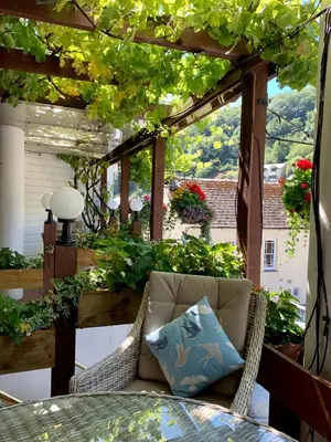 a patio with a table and a chair and a window at The Claremont Hotel-Adult Only in Polperro
