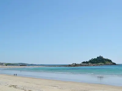 a beach with people walking on the sand and the ocean at Kataluma in Germoe