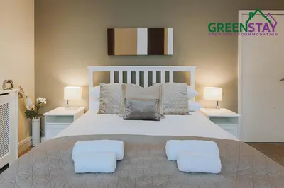 a bedroom with a large white bed with two lamps at 