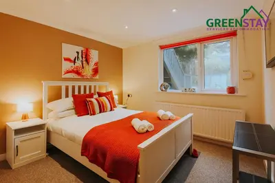 a bedroom with a bed with orange walls and a window at 