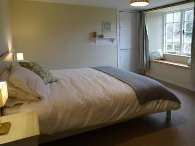 a bedroom with a large bed with a window at Kingbarth in Lerryn