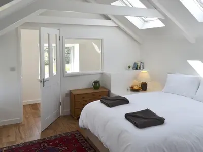 a bedroom with a white bed with black towels on it at The Studio in Germoe