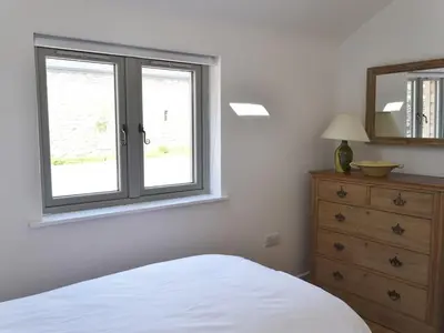 a bedroom with a bed and a window and a dresser at The Studio in Germoe