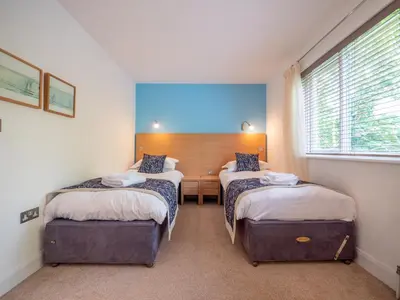 a room with two beds and a desk and a window at The Valley in Perranwell