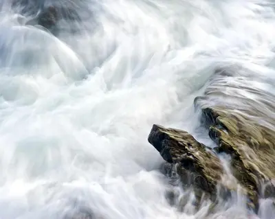 a close up of water rushing over rocks at Talehay Cottages in Looe