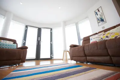 a living room with two couches and a rug at Horizons Apartments Newquay in Newquay