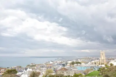 a city with a clock tower and the ocean at Horizons Apartments Newquay in Newquay