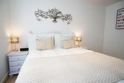 a bedroom with a large white bed with two lamps at Ocean Views 4 in Newquay