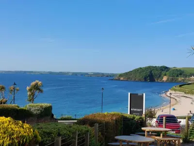 a view of a body of water with tables and a beach at Anacapri in Falmouth