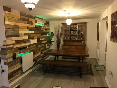 a room with a table and a wall of reclaimed wood at Luxurious House in Cornwall in Truro