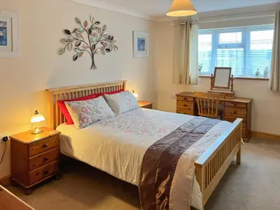a bedroom with a bed and a desk with a mirror at Swallows Rest in Doublebois