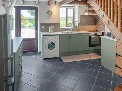 a kitchen with a washing machine and a sink at Beckaveans Stable in Jacobstow