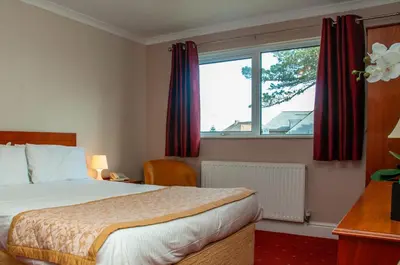 a hotel room with a bed and a large window at Porth Avallen Hotel in St Austell